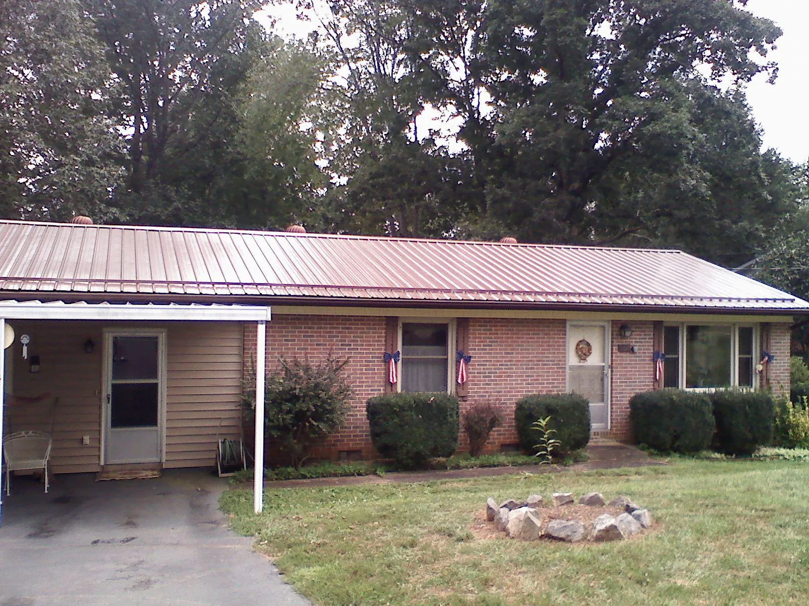 Bronze metal roof and carport on a brick ranch home — Roof Repair work by our crew in Dundee
